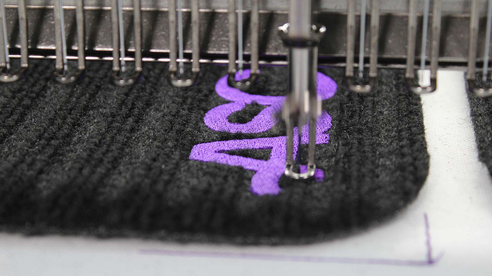 Close-up of the ASC logo being actively stitched into smart textile fabric